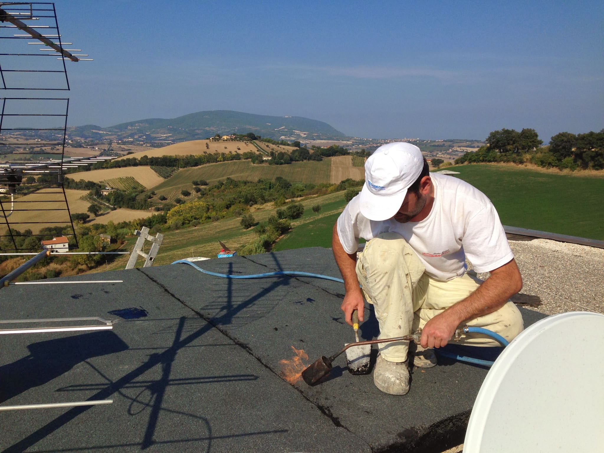 Artigiano al lavoro su una copertura nelle Marche